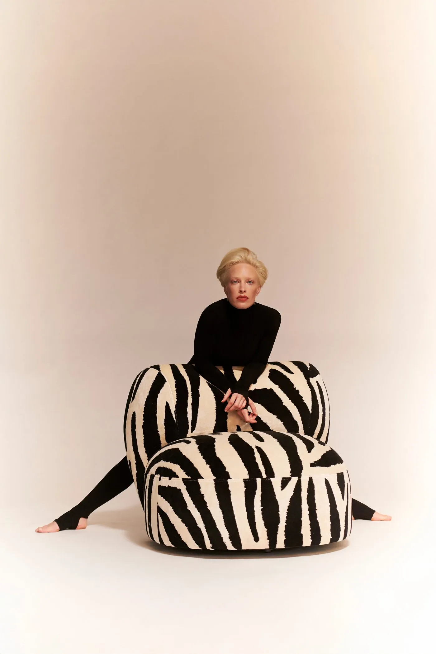 Frau auf einem Tharuun Sessel mit Zebra-Bezug